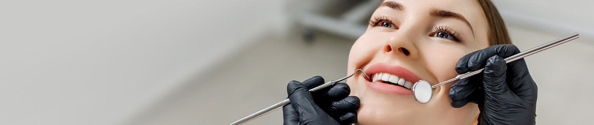 A well-lit reception area with a desk, computer monitor, and potted plant.