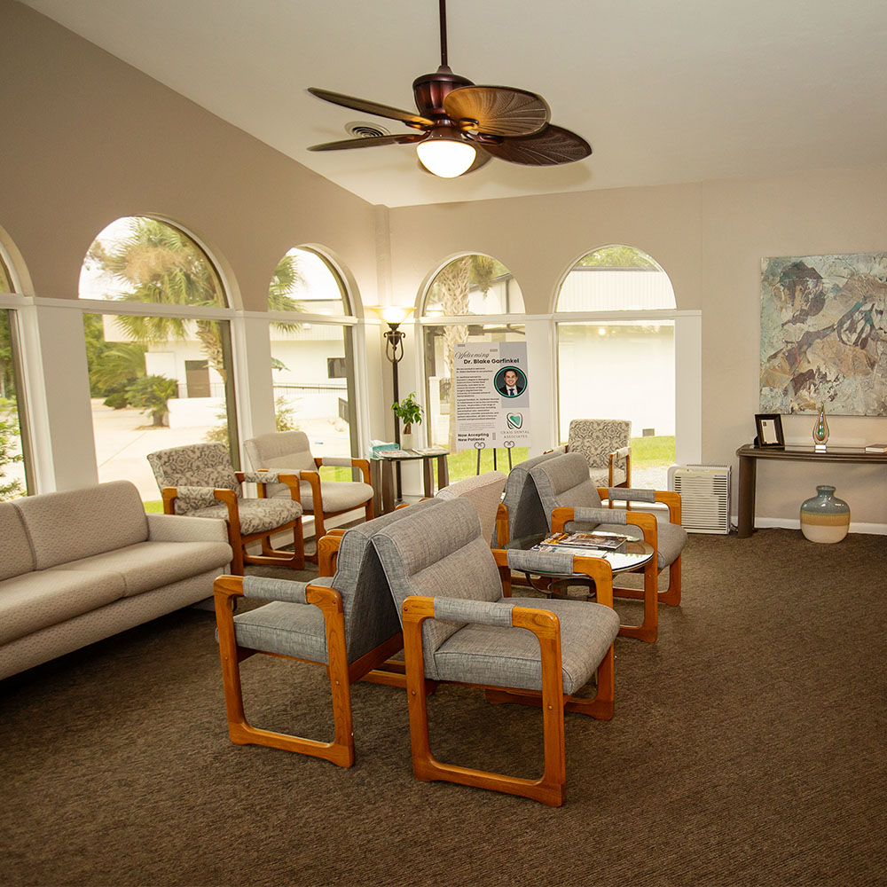 The image shows a modern office space with a sleek desk, chair, and computer setup, featuring wood paneling, a white countertop, and a contemporary design.